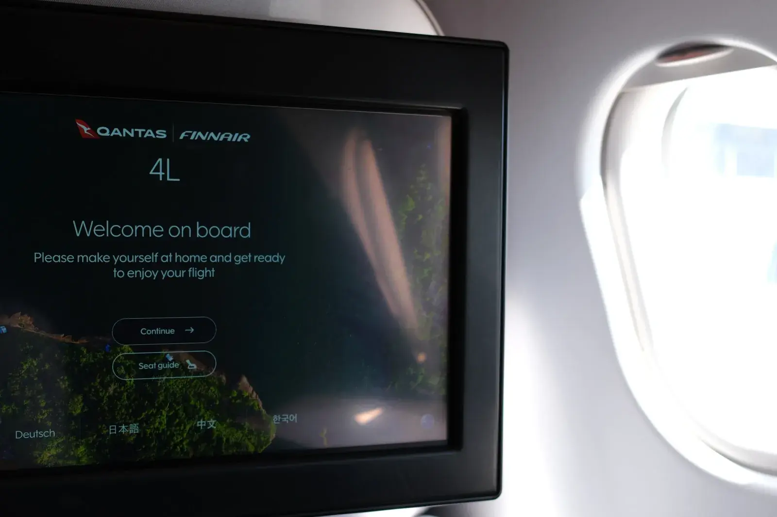 หน้าจอต้อนรับที่นั่งชั้นธุรกิจ แสดงโลโก้ Qantas และ Finnair