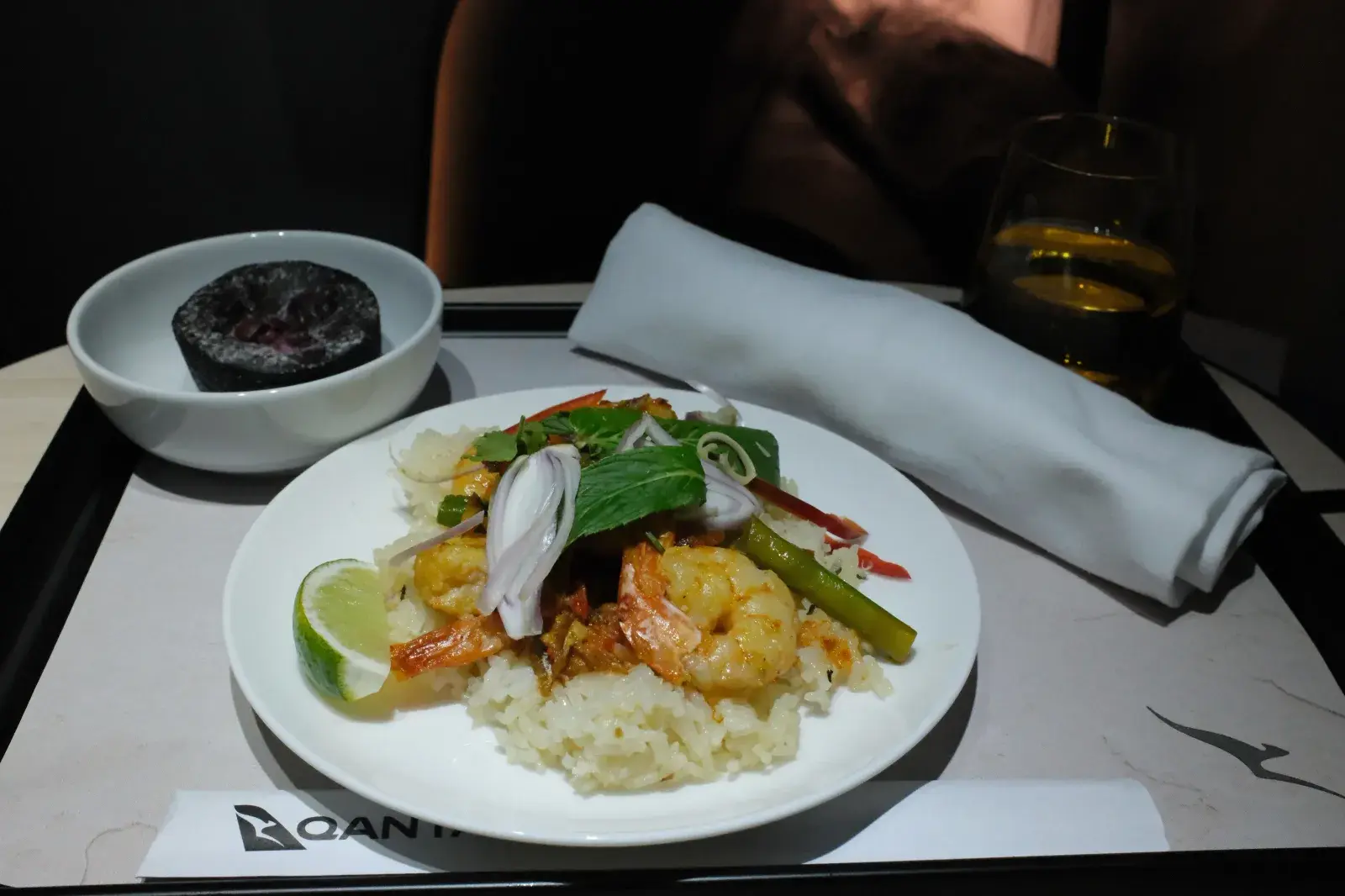 อาหารชั้นธุรกิจ กุ้งผัดสไตล์ไทยกับข้าว เสิร์ฟพร้อมมะนาวและผ้าเช็ดปาก