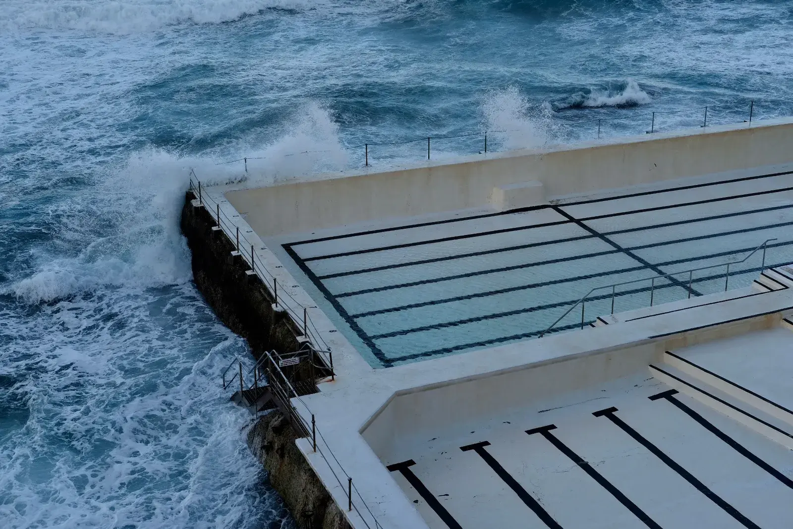 คลื่นทะเลซัดเข้าสระว่ายน้ำริมทะเล Bondi Icebergs ที่หาด Bondi ซิดนีย์