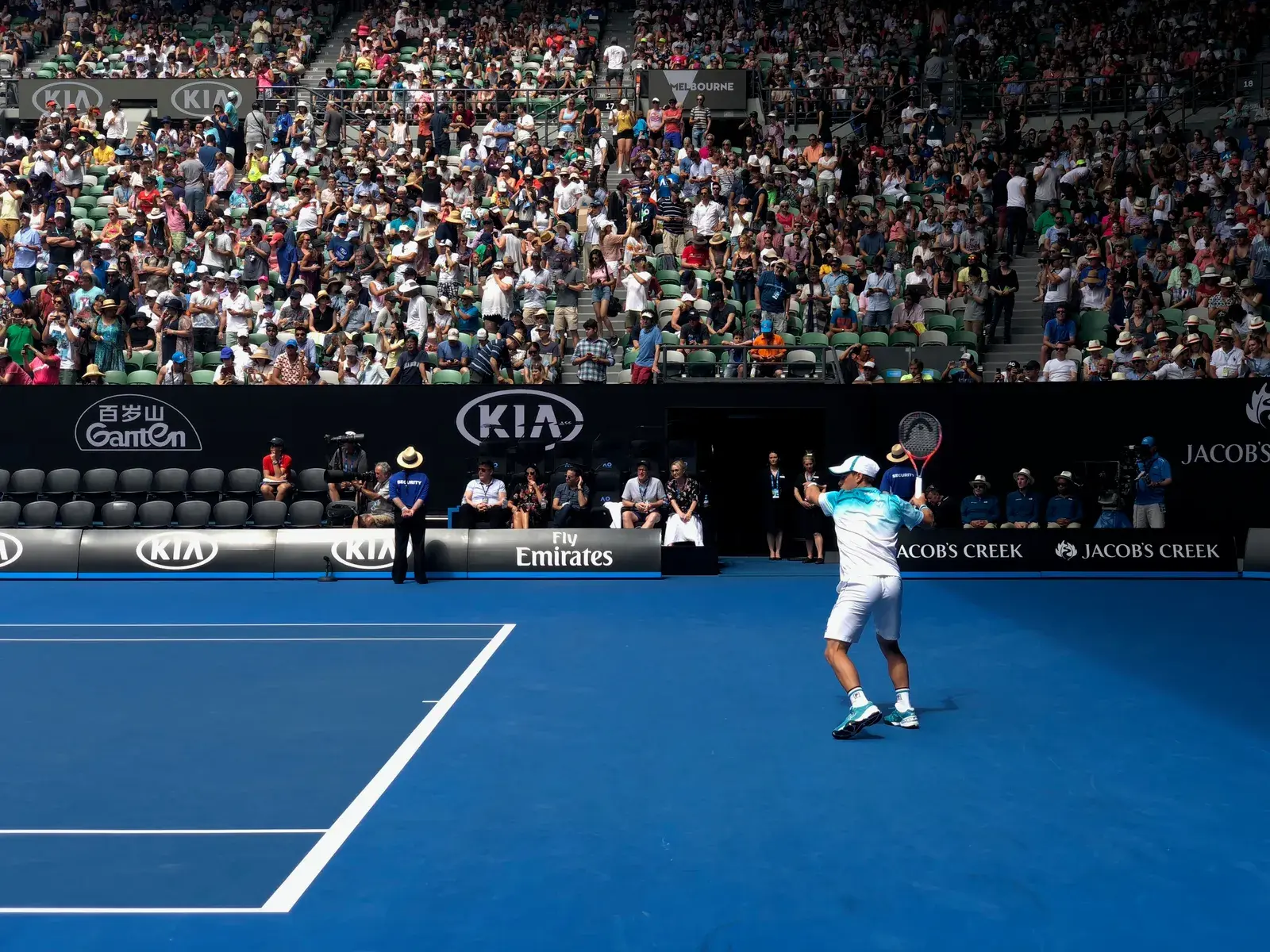 นักเทนนิสกำลังเสิร์ฟต่อหน้าผู้ชมเต็มอัฒจันทร์ในการแข่งขัน Australian Open ที่เมลเบิร์น